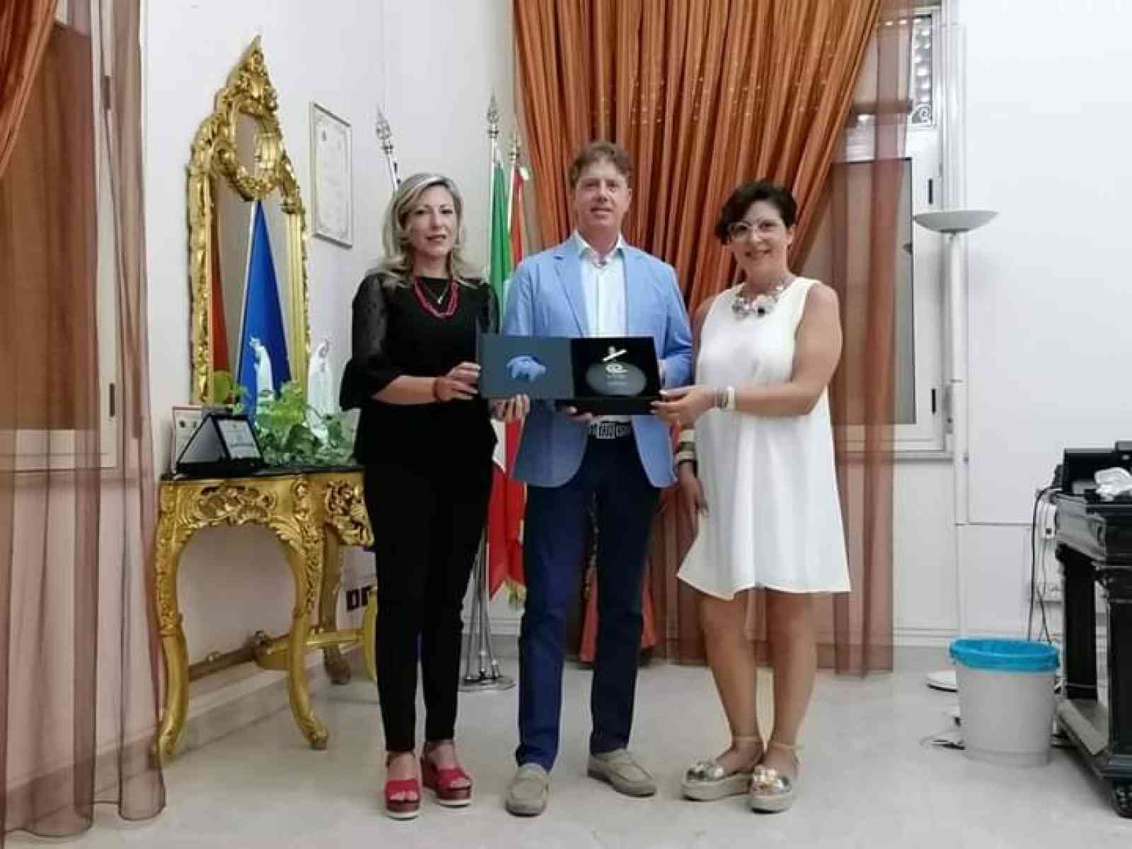 Immagine articolo: Le imprenditrici siciliane Giusy Gambini e Carmen Bonfante regalano al Sindaco Castiglione una bottiglia del pluripremiato olio “Embrace”